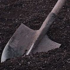 a shovel laying in the ground with dirt around it