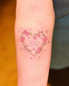 a woman's arm with a heart shaped tattoo on it