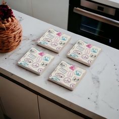 four pieces of paper sitting on top of a counter next to a potted plant