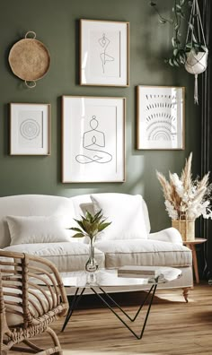 a living room with green walls and pictures on the wall above the white couches