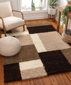 a living room with a chair, rug and potted plant