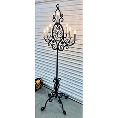 a wrought iron candelabra with five lit candles on it's stand