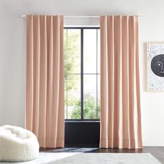 a living room with a white rug and pink curtains