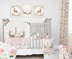 a baby's nursery room with pink and white floral wallpaper, crib bedding, and deer themed decor