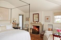 a bedroom with a bed, chair and fire place in the fireplace is decorated in white