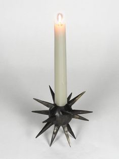 a candle with spikes on it sitting in front of a white background