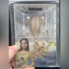 the beauty and the beast necklace set is shown in its packaging box with an image of a woman holding a rose