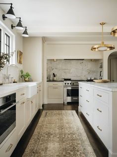 a kitchen with white cabinets and an area rug