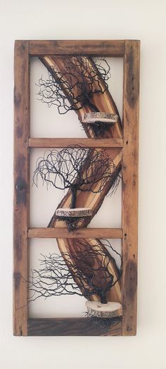 a wooden frame with branches in it hanging on the wall