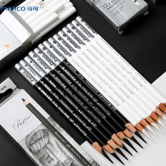 the pencils are lined up on the table next to each other and some pens