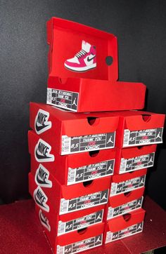 several red boxes stacked on top of each other with white and pink shoes in them