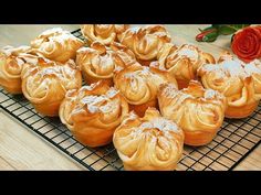 there are many pastries sitting on the cooling rack next to a rose that is laying beside it