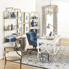 a living room filled with furniture and a white table topped with a blue chair next to a book shelf