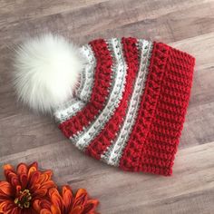 a crocheted hat with a white pom - pom on top