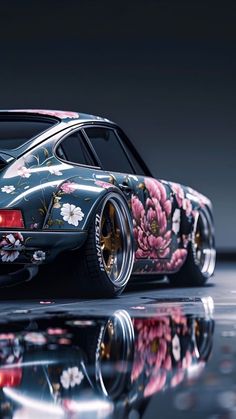 a car with flowers painted on it is parked in front of a reflective surface,