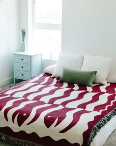 a bed with a red and white blanket on it