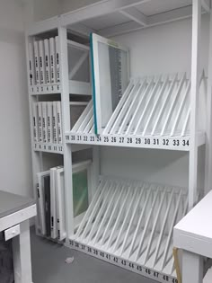 the shelves are filled with many different types of books and computers in white storage units