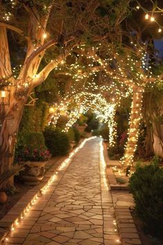 an outdoor walkway is lit up with fairy lights