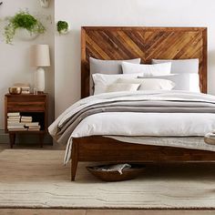 a bed room with a neatly made bed next to a night stand and dressers