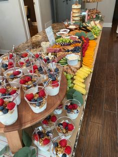 an assortment of desserts are displayed on a buffet table with fruit and other snacks