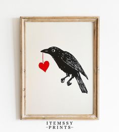 a black bird with a red heart hanging on the wall