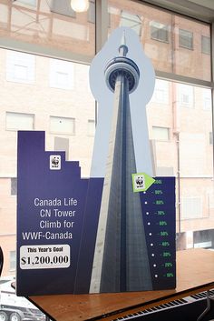 an advertisement for the cn tower is displayed on a table in front of a window