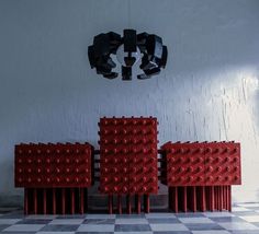 three red chairs sitting next to each other on a checkered floor