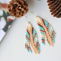 These perfectly joyful and beautiful unique earrings are the perfect way to show off your love of the harvest season. An unexpected combination of pearl, maize, peach, brown and turquoise this pair is reminiscent of flint corn and brings all the fall vibes. Beautiful on any skin tone or hair color. Details: Handcrafted by artisans in Medellin, ColombiaMaterials: Seed beads, stainless steel hardware for comfort and longevitySize: Approximately 3.5 inches from top of hook, 1 inch wideSKU: E1144 FO Western Beaded Earrings, Flint Corn, Earring Inspired, Brown And Turquoise, Stitch Earrings, Diy Jewelry Earrings, Bead Earring, Brick Stitch Earrings, Beaded Earrings Patterns