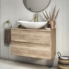 a bathroom vanity with a round mirror above it and a white bowl sink on the counter