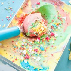 an ice cream sundae with sprinkles on it and a blue spatula