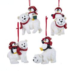 three white polar bear ornaments hanging from red ribbon with penguin and penguinling on top