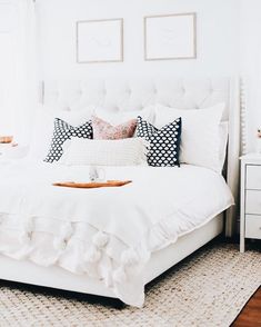 a white bed sitting in a bedroom on top of a rug