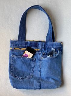 a blue jean purse sitting on top of a white surface