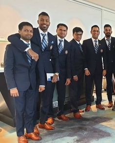 a group of men standing next to each other in suits and ties, posing for the camera