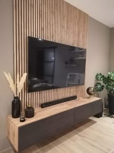 a flat screen tv mounted to the side of a wooden wall in a living room