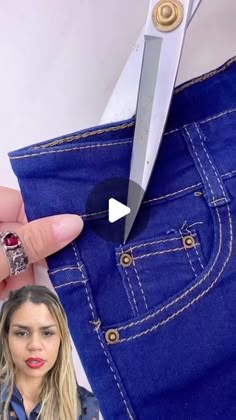 a woman is cutting through her jeans with a pair of scissors in front of her