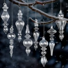 an assortment of glass ornaments hanging from a tree branch