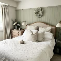 a white bed sitting in a bedroom next to a window