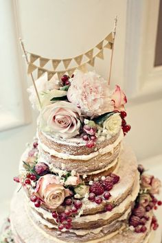 a wedding cake with flowers and bunting on top