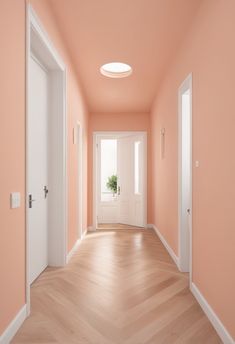 an empty hallway with pink walls and white doors