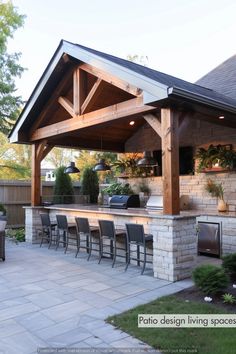 an outdoor kitchen and grill area with chairs