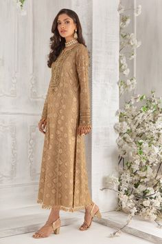 Crafted on luscious Pure chiffon canvas, this A-line shirt features embellished neckline and sleeves with dabka, pearls, beads and tila work. This exclusively curated shirt is further highlighted with laboriously detailed tasseled border on hem and sleeves to add glamour and oomph. Off set with pure chiffon sequin and bead embellished dupatta with beautifully composed border and Gold jamawar straight pant. Shirt Fabric: Pure Embroidered chiffon Shirt Length: 48” (Customisable, mention in order n Elegant Georgette Kaftan For Reception, Traditional Embellished Lawn Suit With Long Sleeves, Designer Gold Kaftan With Dabka Work, Embellished Anarkali Lawn Suit With Long Sleeves, Embellished Long Sleeve Anarkali Lawn Suit, Elegant Embellished Lawn Suit For Festive Season, Elegant Embellished Festive Lawn Suit, Elegant Lawn Suit With Dabka For Reception, Reception Lawn Suit With Dabka And Long Sleeves