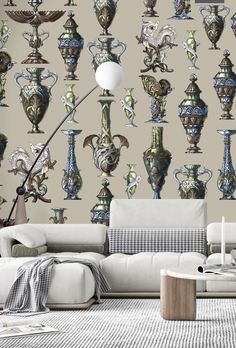 a living room filled with lots of vases on the wall next to a white couch