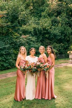 the bride and her bridesmaids pose for a photo in front of some trees