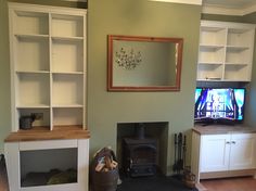 a living room filled with furniture and a flat screen tv on top of a wooden shelf