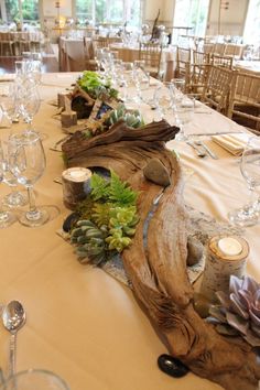 the table is set up with candles and succulents for an elegant dinner