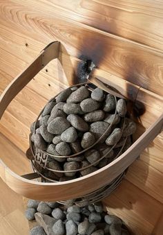 a bucket filled with rocks sitting on top of a wooden floor