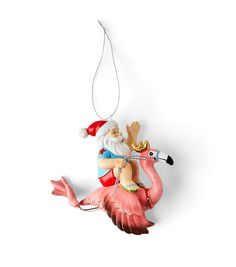 a christmas ornament with a santa riding a flamingo on it's back