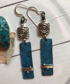 As blue as the water in the pool, these sunny, lightweight earrings combine Silver and Blue to perfection. The copper patina charms are textured and wrapped. The earrings measure 2-1/4 inches long. Silver findings and ear wires. Blue Artisan Copper Earrings, Artisan Blue Copper Earrings, Blue Copper Wire Wrapped Earrings, Artsy Blue Metal Jewelry, Unique Blue Copper Earrings, Artsy Nickel-free Blue Jewelry, Artsy Blue Nickel-free Jewelry, Blue Patina Earrings For Gift, Blue Bohemian Hand Forged Earrings