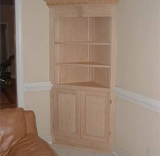 a living room with a brown leather chair and bookcase in the corner by the wall